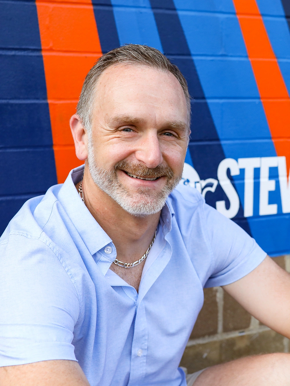Dr. Steve Horvath smiling in front of his COVE mural artwork